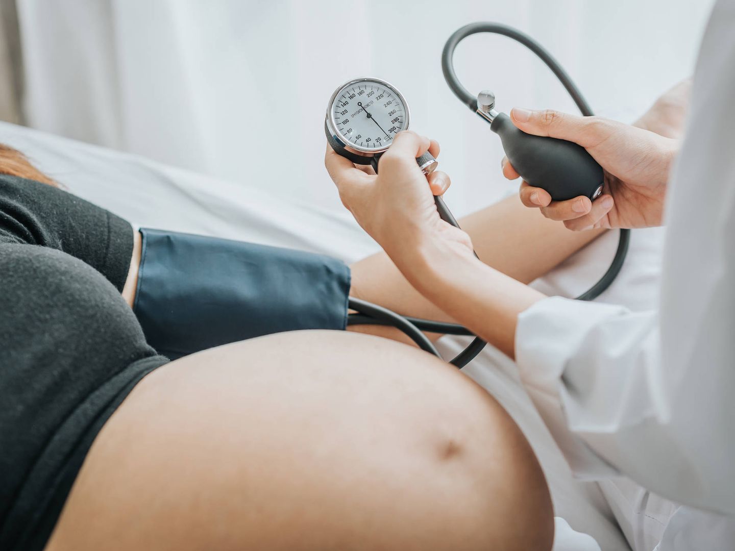 Una médica toma la tensión a una mujer embarazada. (iStock)