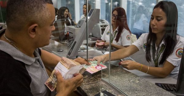 Foto: Emleados de banca empiezan a operar con los nuevos billetes en una entidad de Caracas, el 16 de enero de 2017 (EFE)