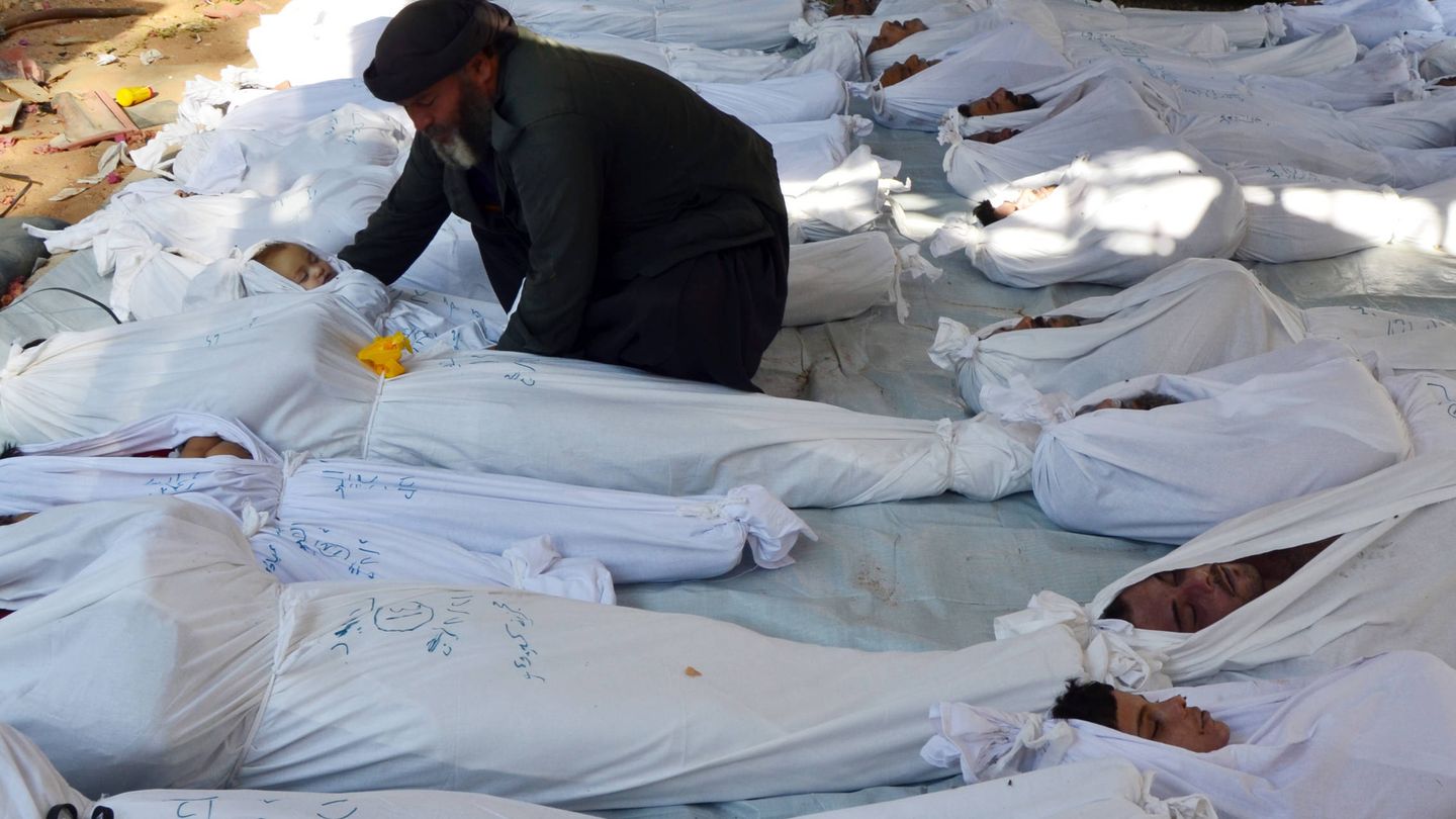 Un hombre sostiene el cadáver de un niño tras el ataque químico de Guta, en agosto de 2013. (Reuters)