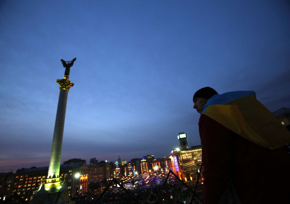 Foto: Un manifestante cubierto por una bandera ucraniana protesta en la Plaza de la Independencia, en Kiev (Reuters).