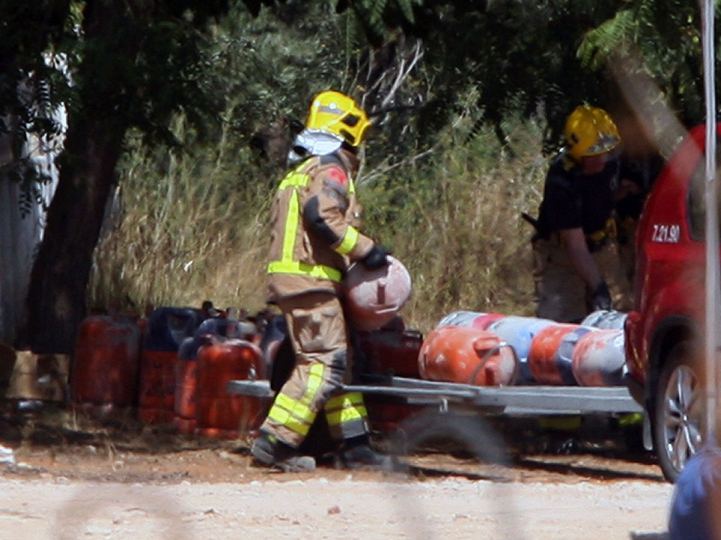 Los bomberos trasladan las bombonas de butano de la casa donde se produjo la explosión en Alcanar (Tarragona). (EFE)