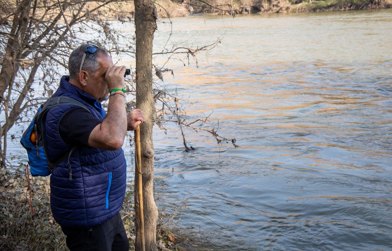 Un hombre busca, a orillas del río Ebro, alguna pista que ayude a encontrar a Javier. (EFE)