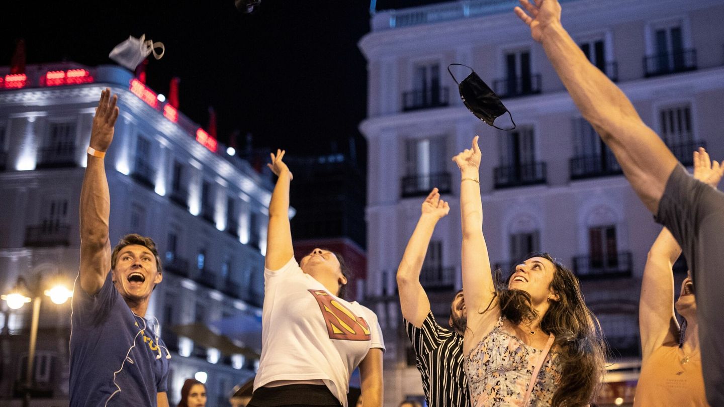 Varias personas celebran el fin del uso obligatorio de la mascarilla en la Puerta del Sol. (EFE) 