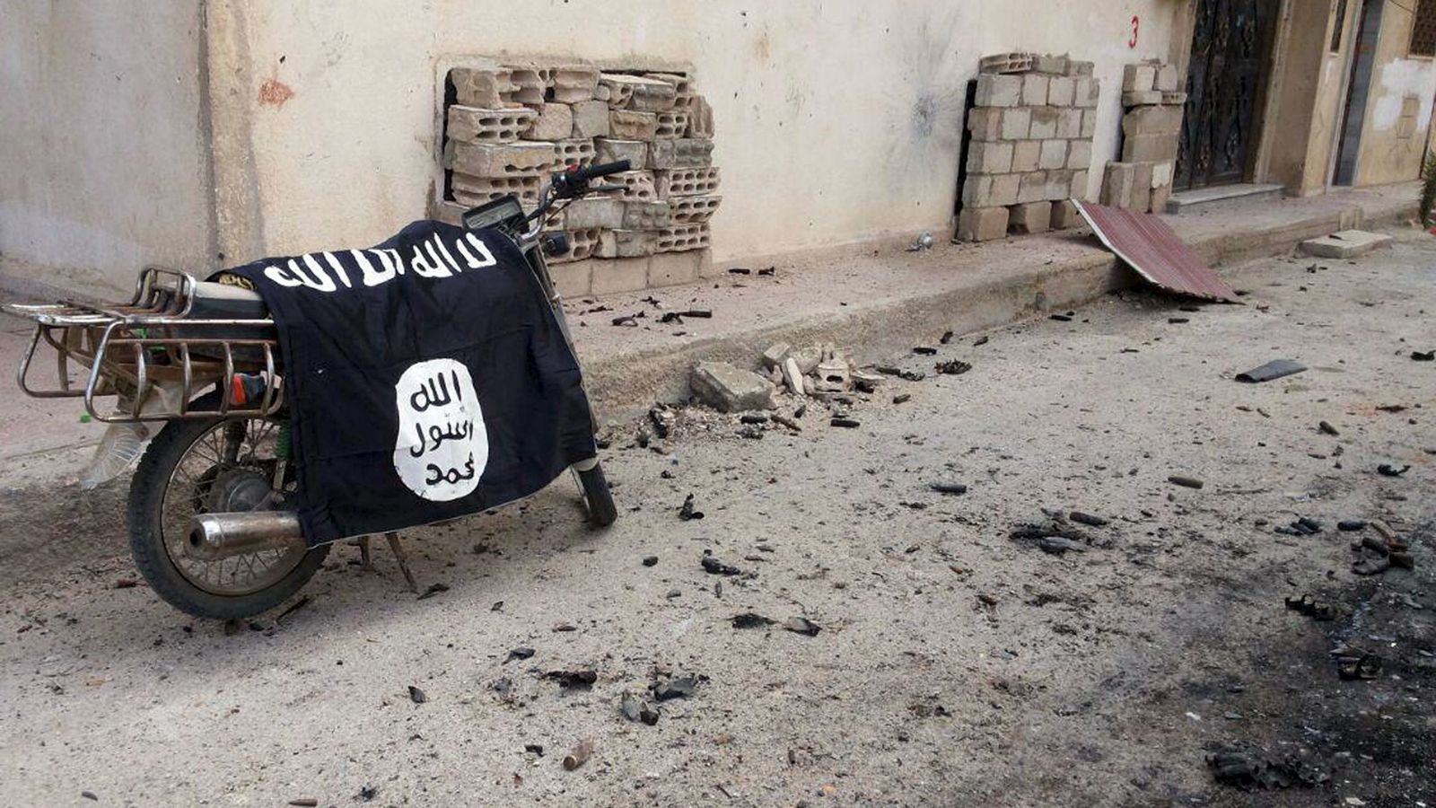 Foto: Una bandera del Estado Islámico apoyada en una motocicleta en Palmira, Siria. (Reuters)