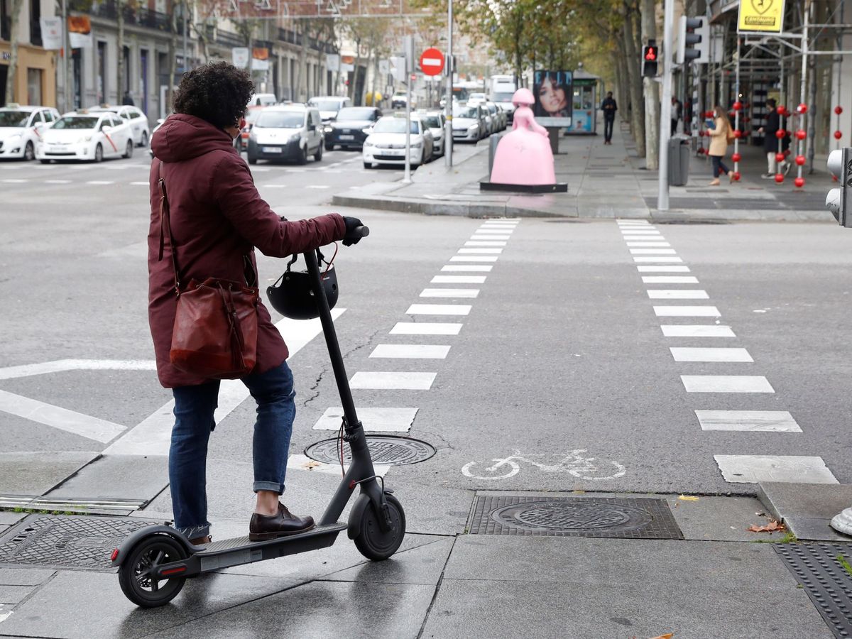 Foto: Una mujer en un patinete eléctrico en las calles de Madrid. (EFE/J.J. Guillén)