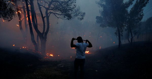 Foto: Un hombre usa ropa para protegerse del humo en Rafina, Grecia. (Costas Baltas / Reuters)