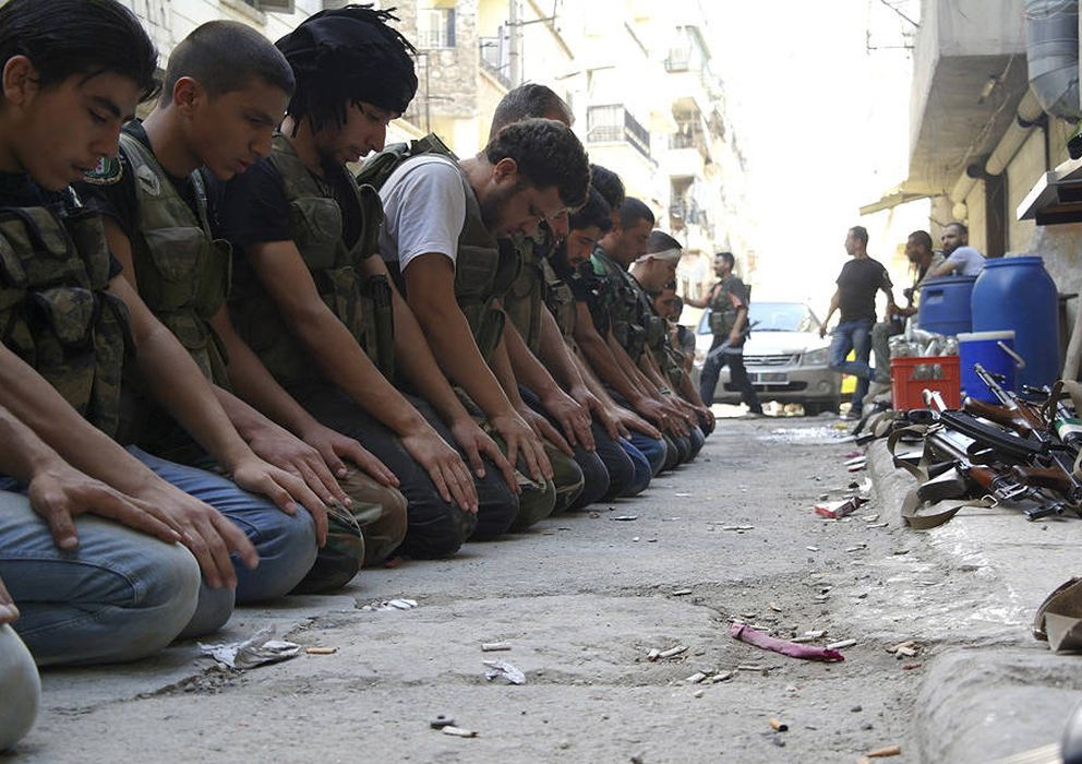 Foto: Combatientes del Ejército de Liberación Sirio rezan en una calle de Alepo (reuters).