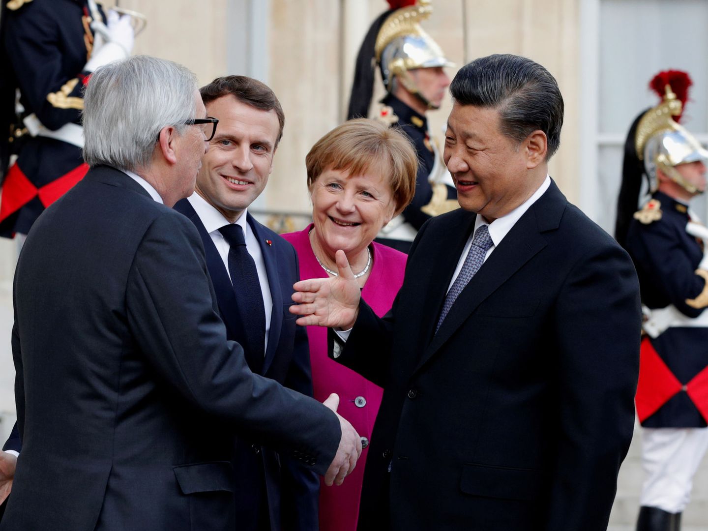 El presidente de la Comisión Europea saluda al presidente chino ante las miradas de Macron y Merkel. (Reuters)