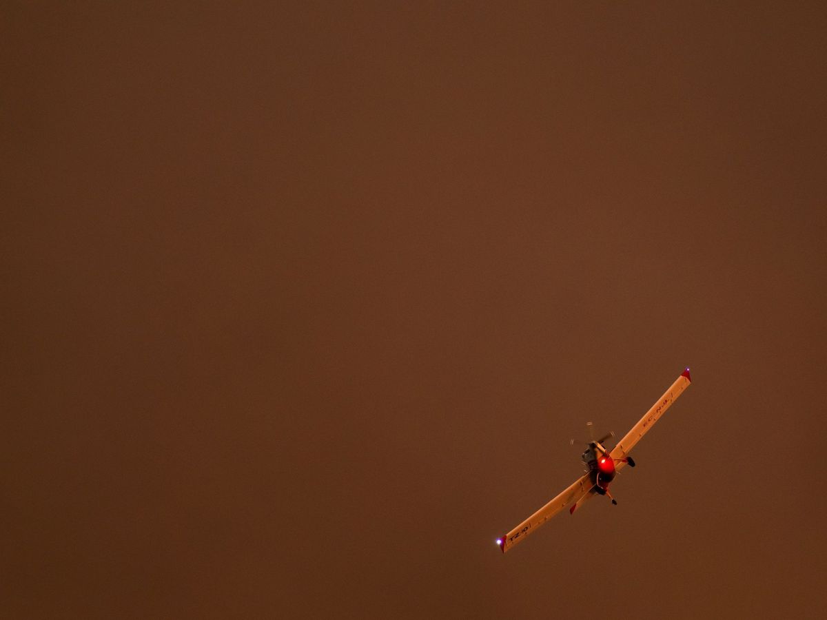 Foto: Imagen de una aeronave sobrevolando el incendio de Almonaster. (EFE)
