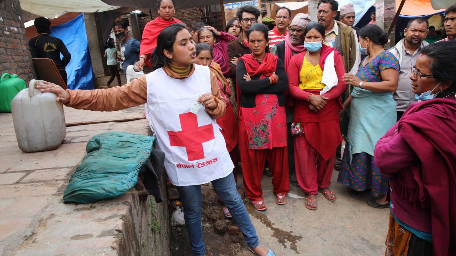 Foto: Una voluntaria de Cruz Roja enseña cómo utilizar pastillas de purificación de agua en Nepal. (Cruz Roja)