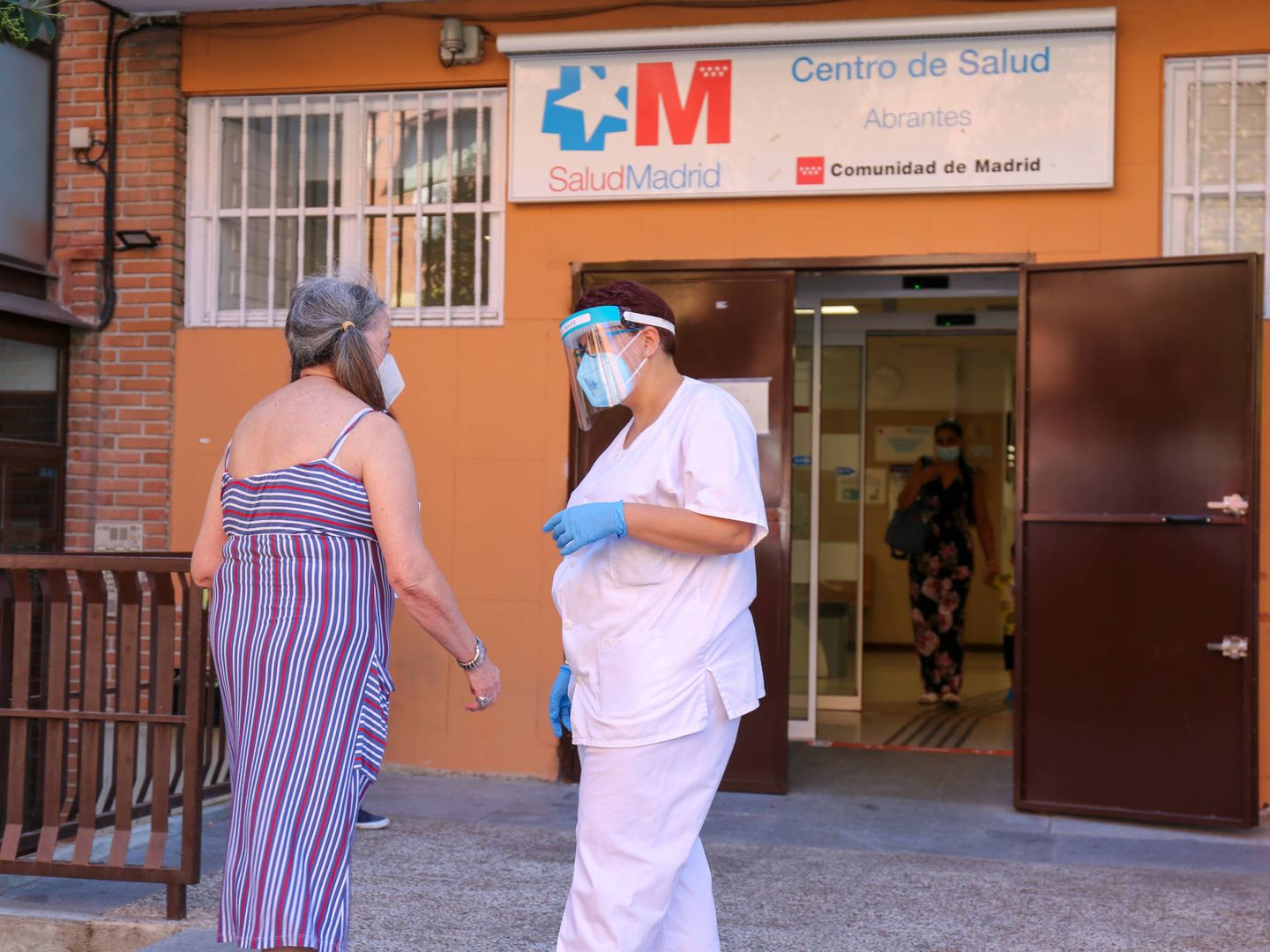 Una enfermera atiende a una paciente frente al centro de salud de Abrante (Madrid). (D. Brunat)