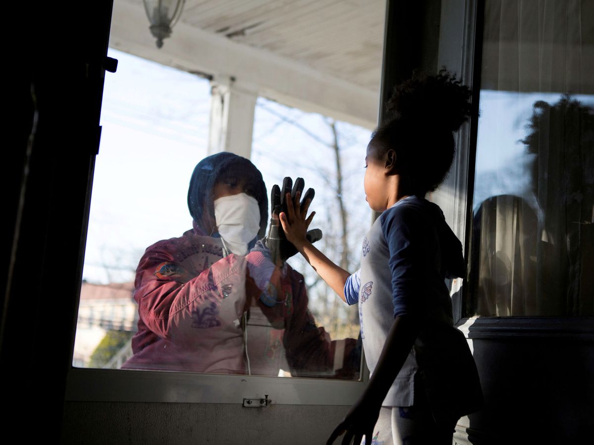 Foto: Una médico saludando a su hija en su casa de Nueva York. (Reuters)