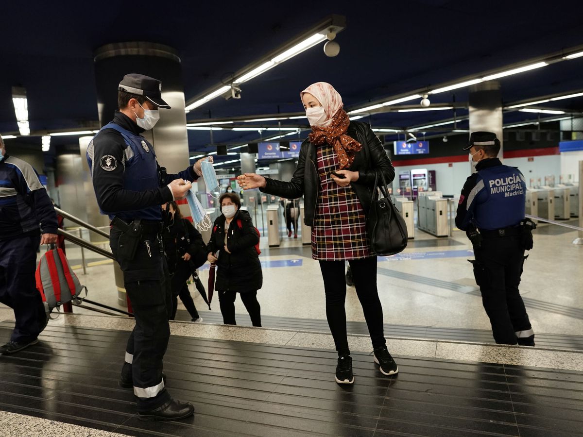 Foto: Los cuerpos de la Policía Municipal reparten mascarillas a la entrada del Metro. (Reuters / Juan Medina)