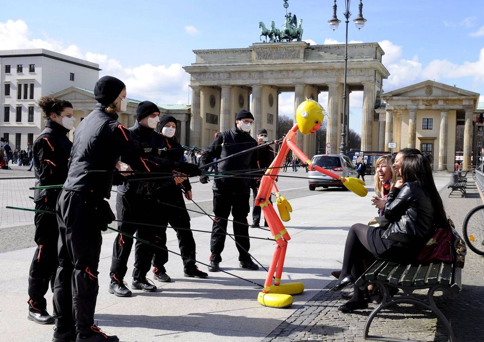 Foto: Jóvenes juegan con una marioneta delante de la Puerta de Brandenburgo en Berlín, Alemania