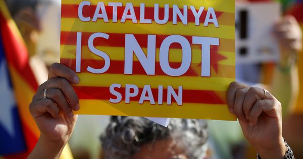 Foto: Una manifestante sostiene una pancarta con el lema 'Cataluña no es España'. (Reuters)