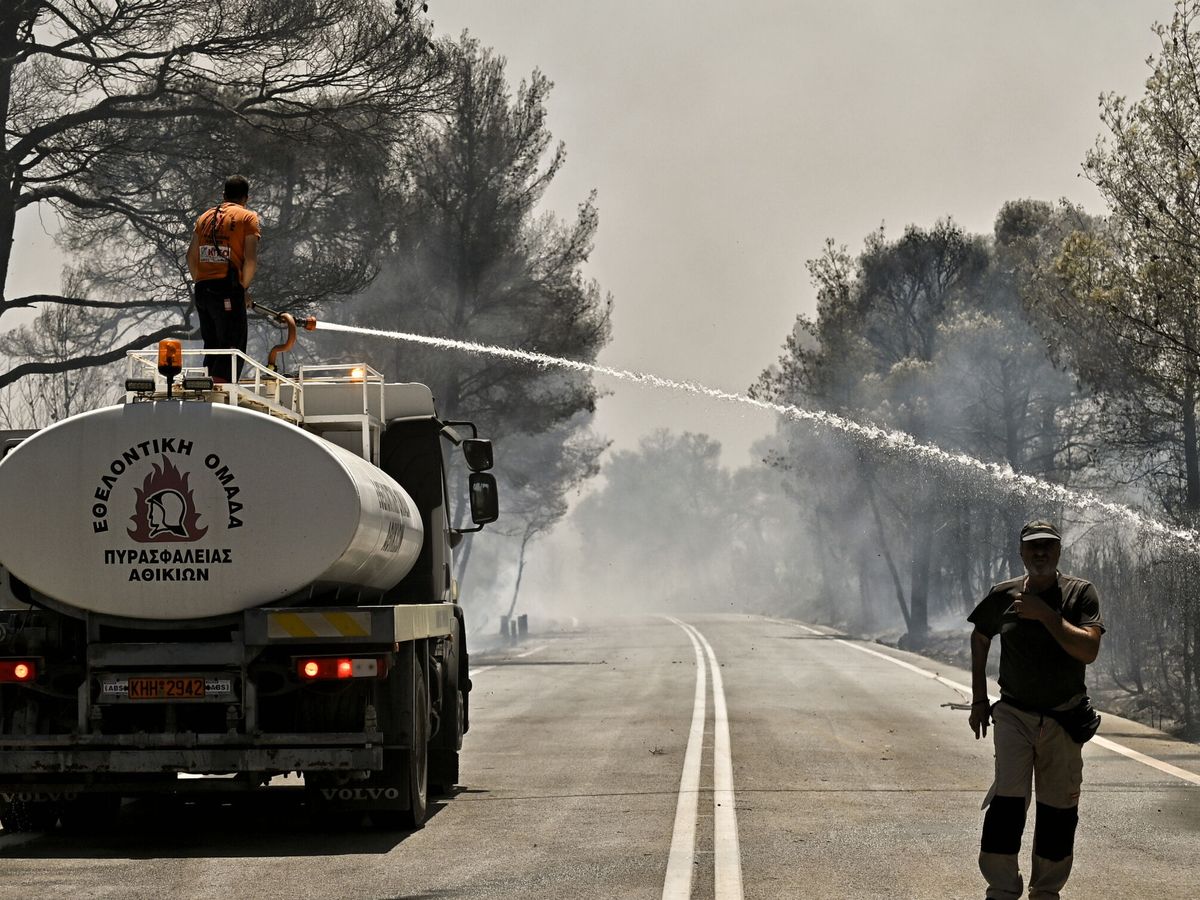 Foto: Voluntarios de bomberos intentan extinguir un incendio forestal en imagen de archivo. (EFE/Vassilis Psomas) 