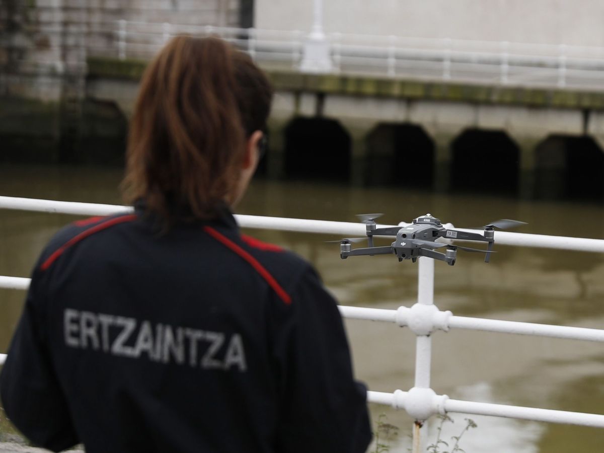 Foto: Una ertzaina realiza un vuelo con un dron en la ría de Bilbao. (EFE/Luis Tejido)