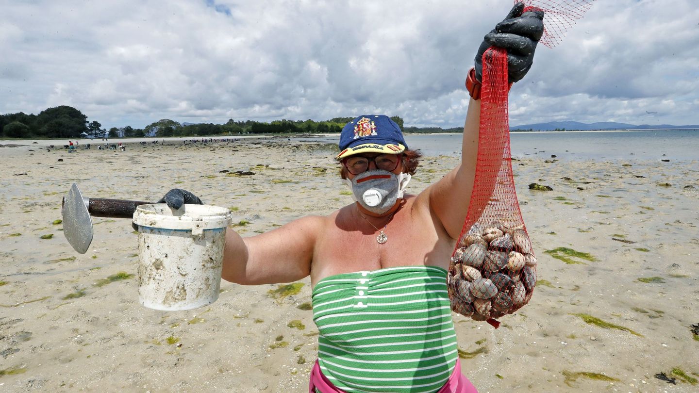 Una mariscadora de la cofradía de la Isla de Arousa con mascarilla, el pasado abril. (EFE)