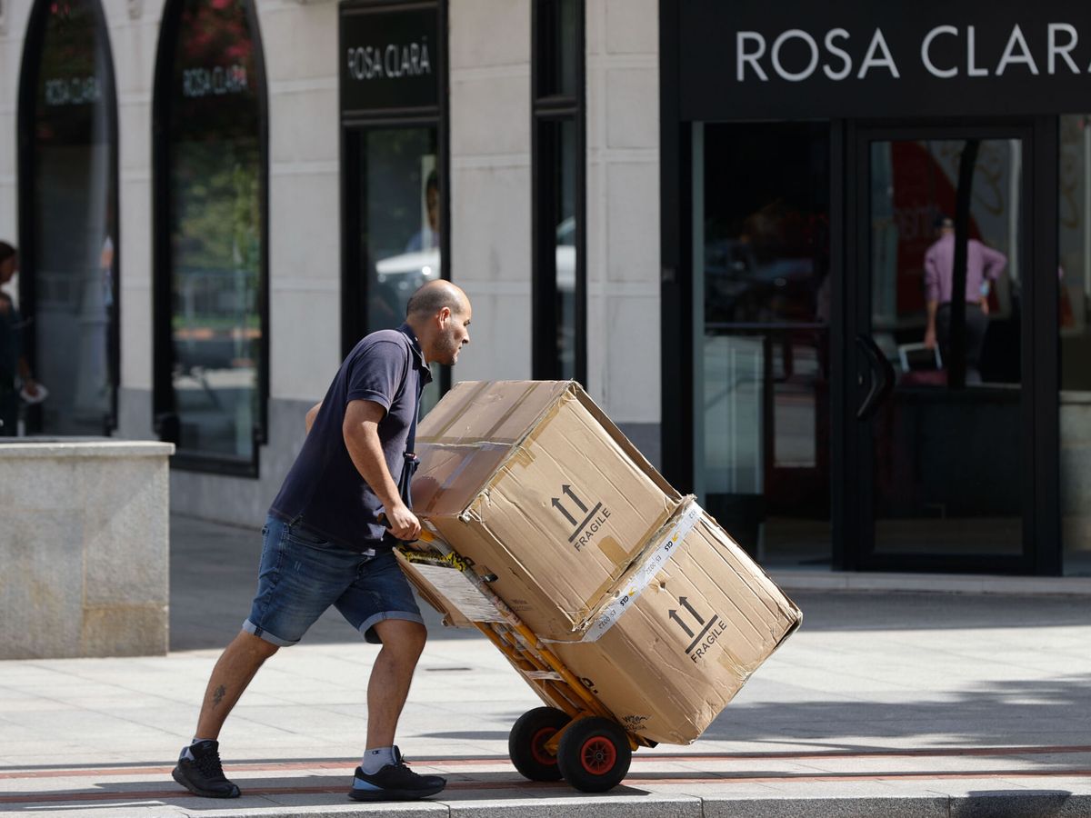 Foto: Un transportista lleva mercancía a un comercio. (EFE/Luis Tejido)