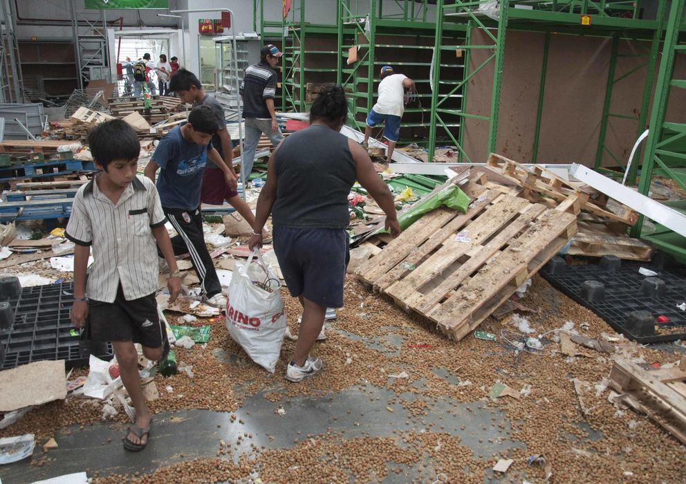 Foto: Argentinos buscan bienes en un comercio destrozado por los saqueadores en Tucamán (Reuters).