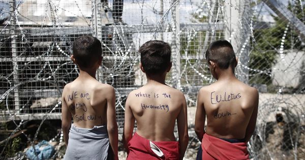 Foto: Un grupo de niños con mensajes en sus espaldas en los que se leen 'Estamos muriendo lentamente', '¿Dónde está la humanidad?' y 'La UE nos falla' en Idomeni, Grecia. (Efe) 