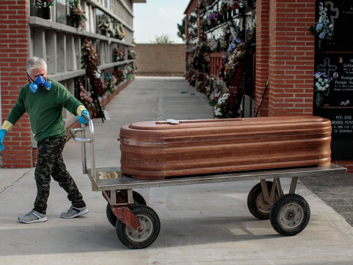 Foto: Un operario de un cementerio de Valencia traslada un féretro. (EFE)