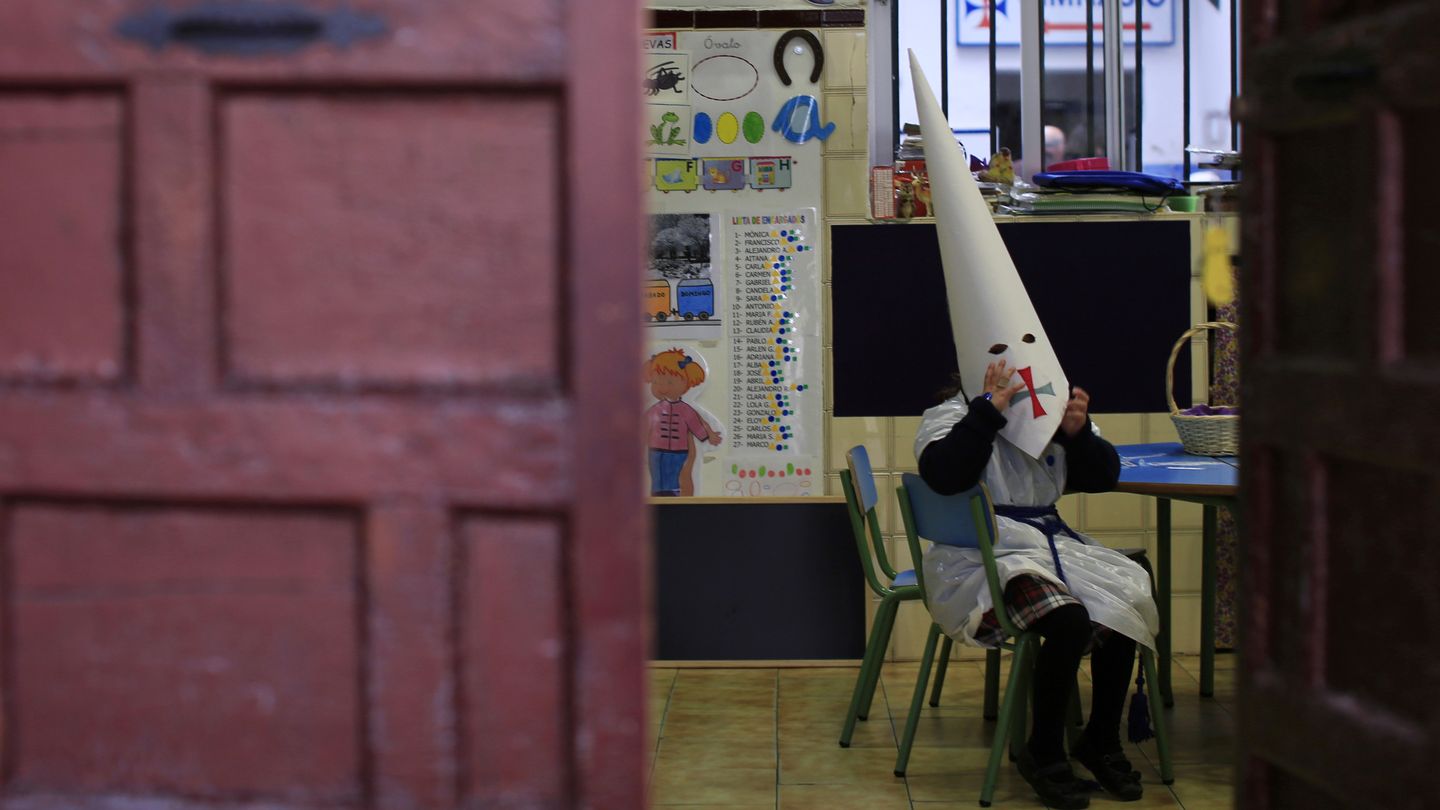 Una niña vestida de penitente en un colegio de Sevilla durante la Semana Santa (Reuters).