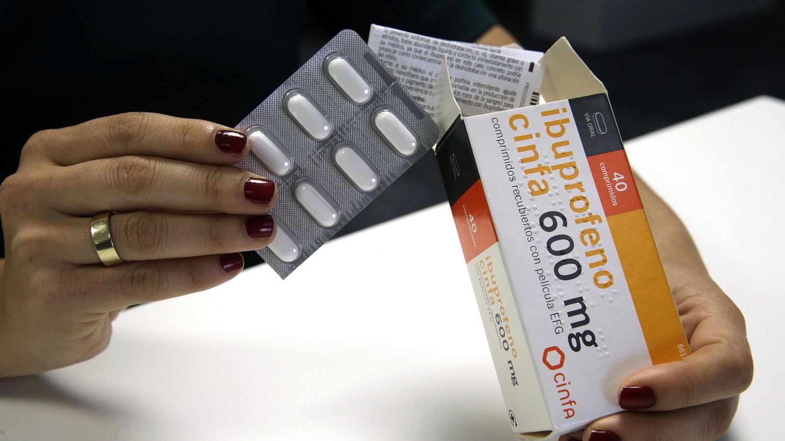 Foto: Una mujer retira una tableta de pastillas de una caja de ibuprofeno. (EFE)