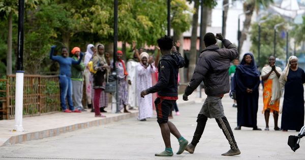 Foto:  Dos de los 52 inmigrantes que han accedido hoy a Melilla tras saltar la valla. (EFE)
