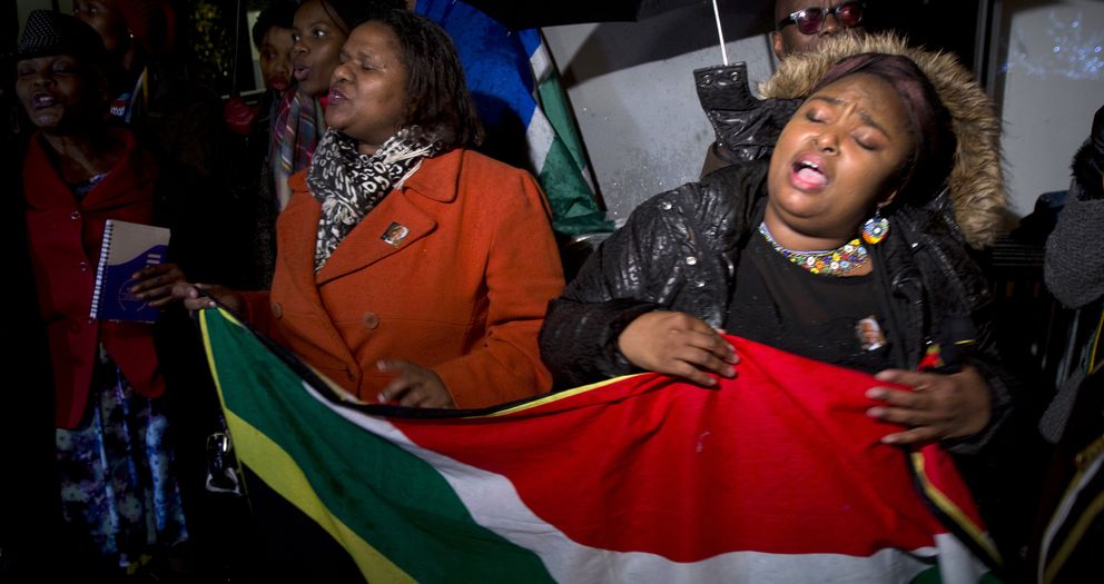 Un grupo de personas canta el himno de Sudáfrica frente a la sede de la ONU (Reuters)