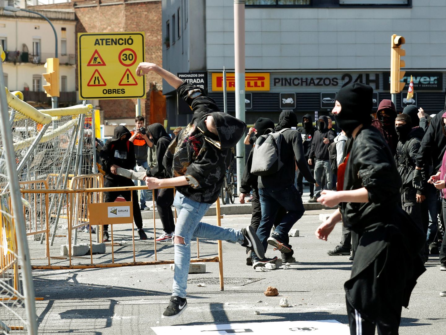 Los manifestantes lanzan piedras contra el cordón policial. (Reuters) 