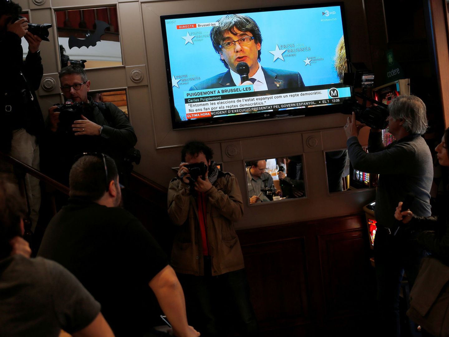 Un grupo de barceloneses sigue la comparecencia de Carles Puigdemont desde Bruselas en un bar. (Reuters)