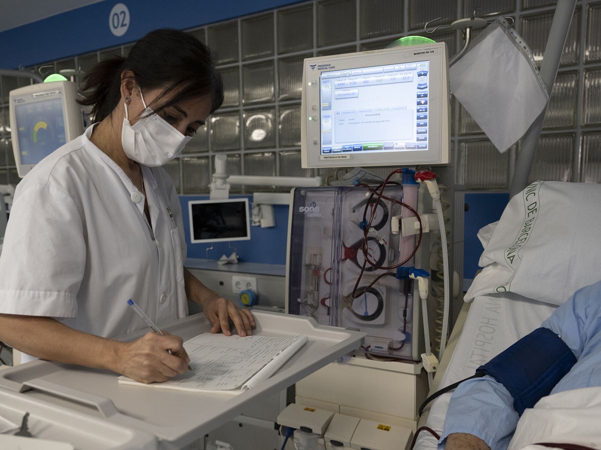Foto: Una sanitaria del Hospital Clínic de Barcelona trabaja tomando notas a mano tras el ciberataque. (EFE/Francisco Avia/Clínic)