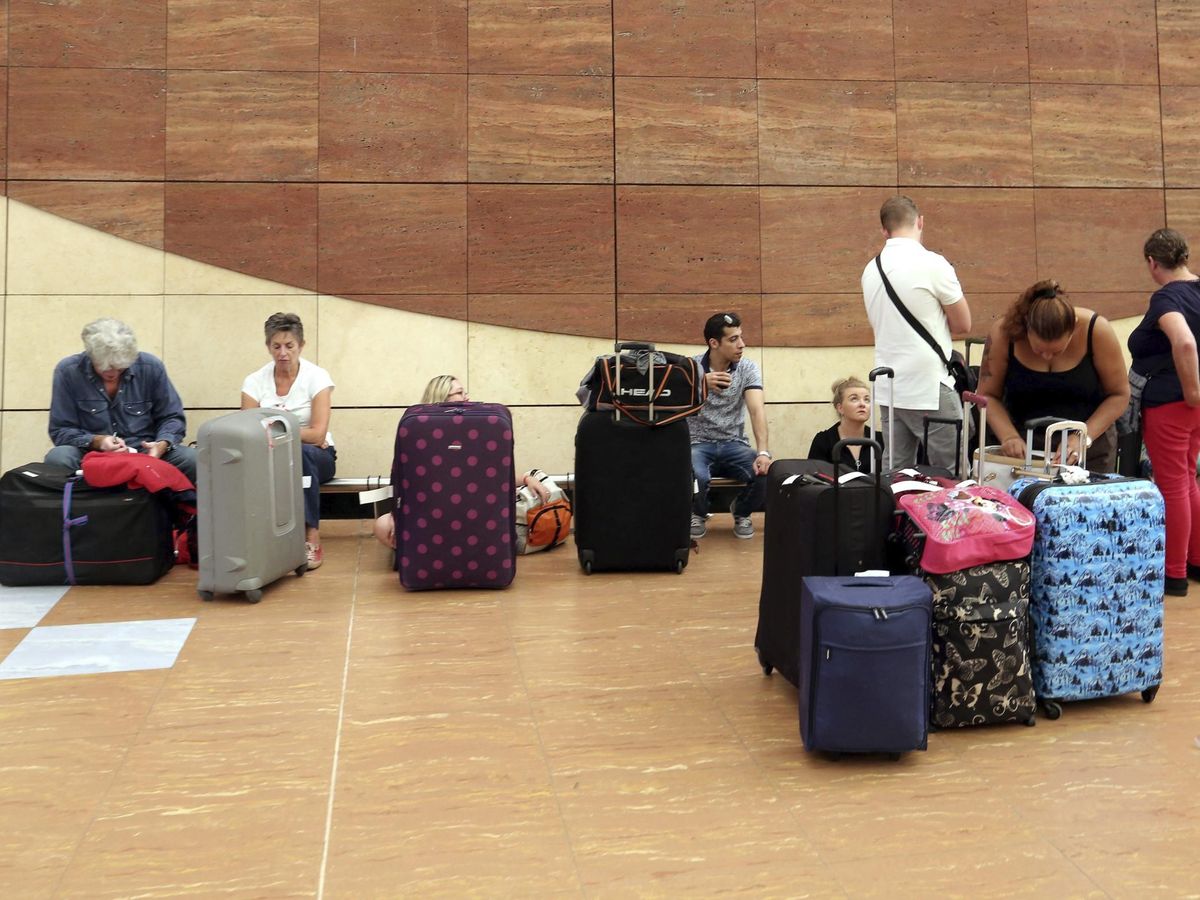 Foto: Turistas esperan con su equipaje en un aeropuerto. (EFE/Khaled Elfiq)