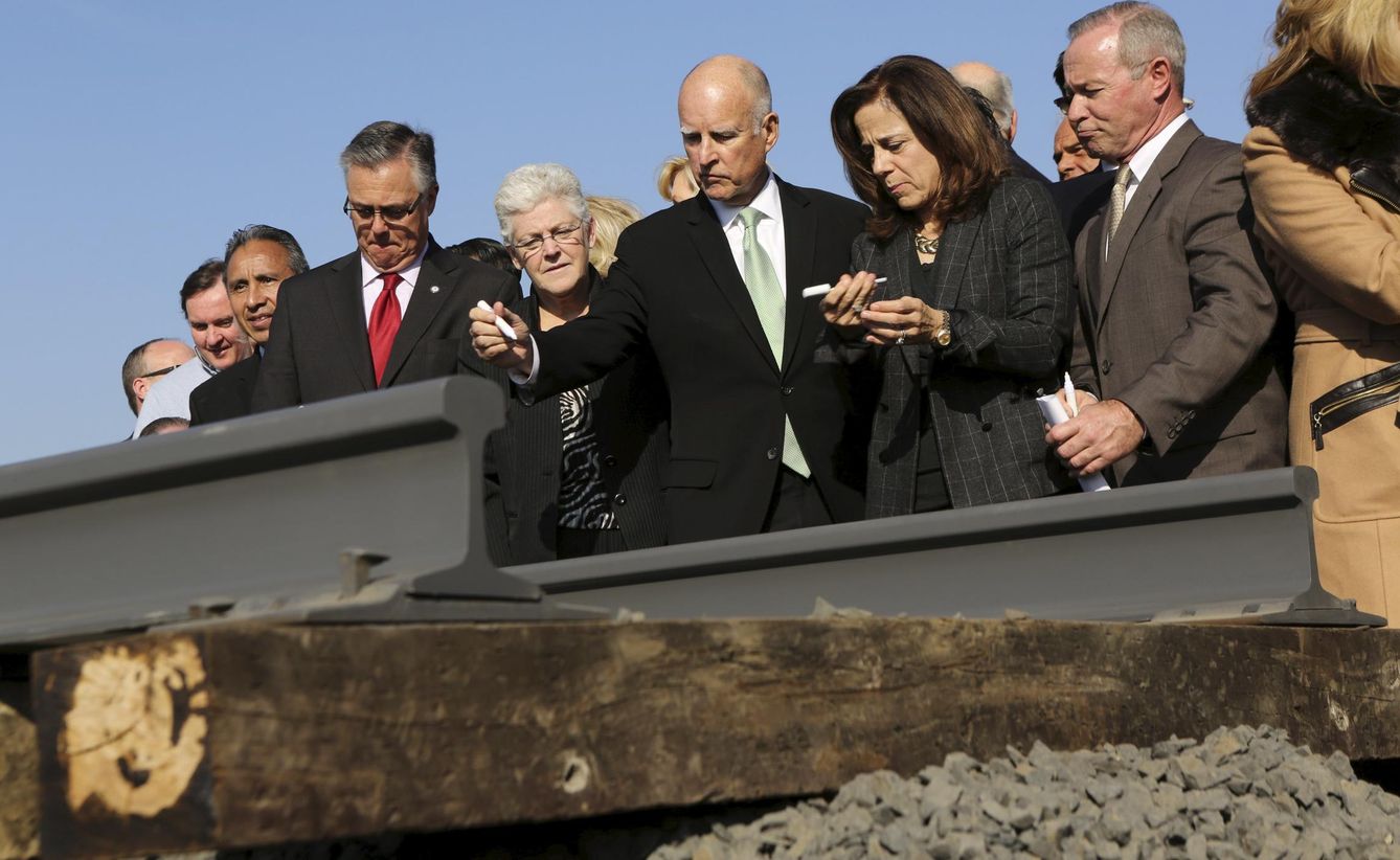 El gobernador de California, Jerry Brown (c), se prepara para firmar un raíl del tren de alta velocidad.