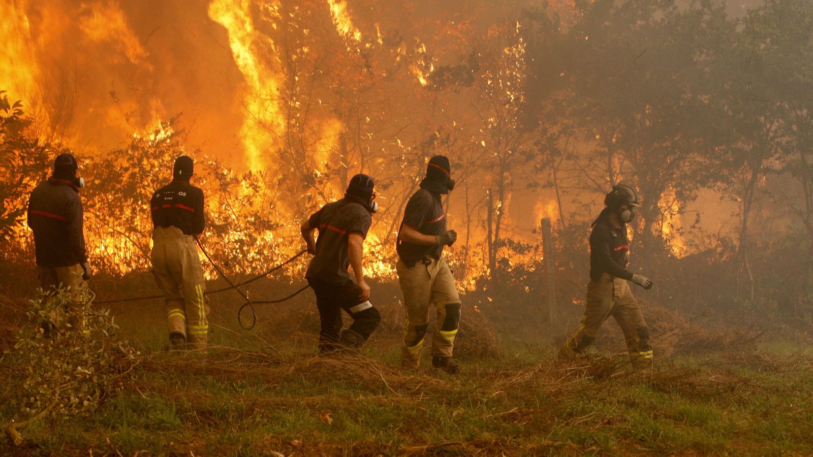 Foto: Operarios de los servicios de extinción de incendios trabajan en la zona de Zamanes, Vigo. (EFE)