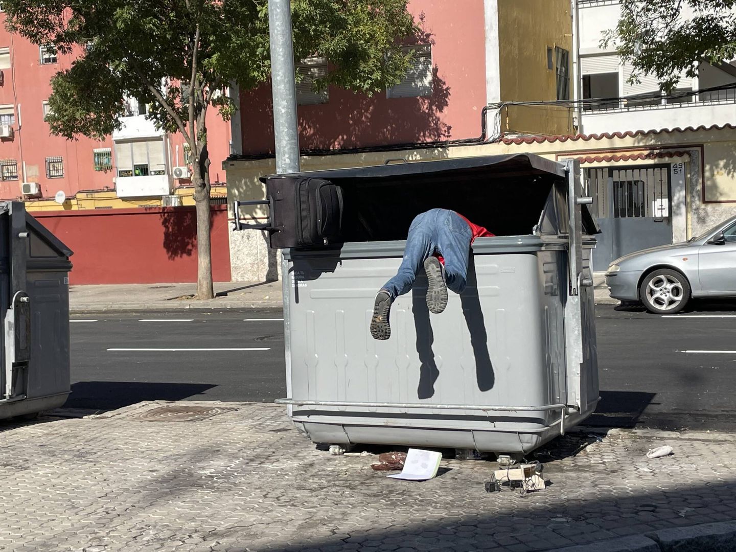 Un vecino rebusca en el interior de un contenedor de basura. (J. L. Losa)