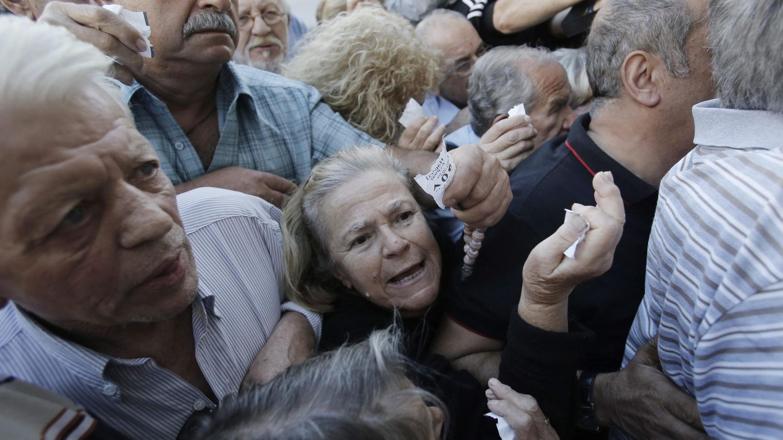 Foto: Una multitud de pensionistas, que no tienen tarjeta de crédito o débito, hace cola ante una sucursal para poder retirar parte de sus pensiones. (EFE)