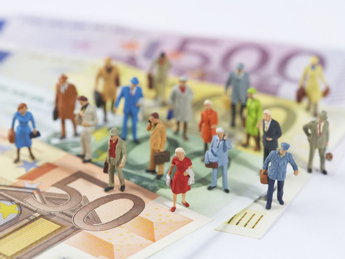 Foto: Ilustración de personas junto a billetes de euros. (iStock)