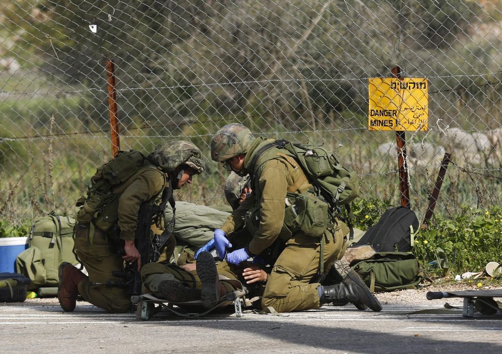 Foto: Un soldado isrelí herido recibe atención médica de varios compañeros. (EFE)