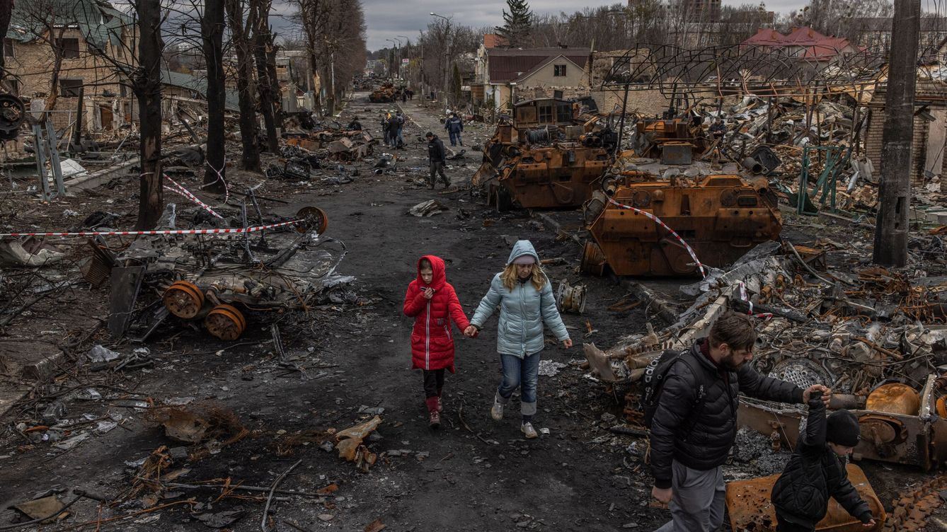 Foto: Una vecina de Bucha, Vladyslava Liubarets, camina con su familia tras la retirada de las tropas rusas. (EFE/Roman Pilipey)