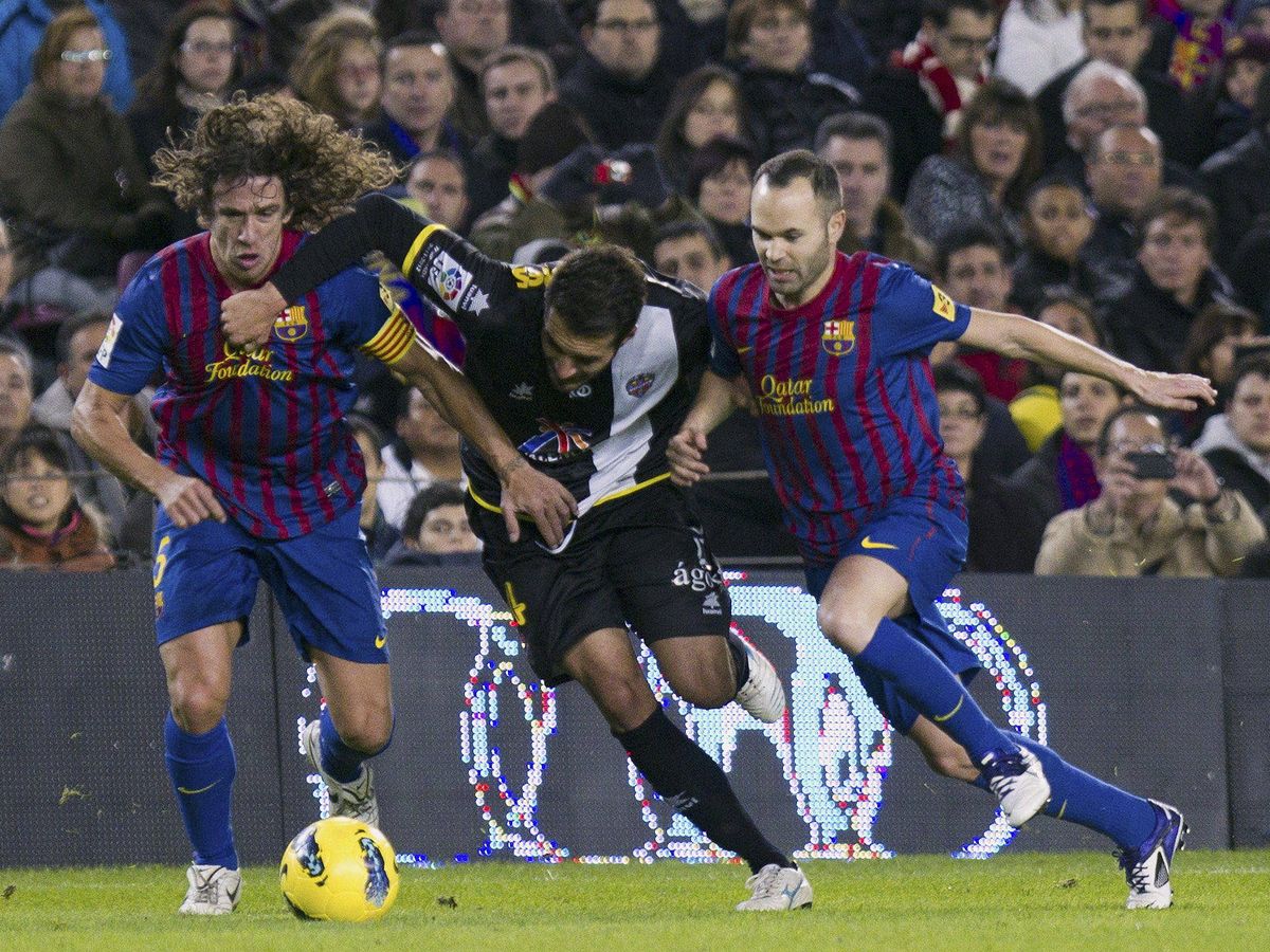 Foto: Carles Puyol y Andrés Iniesta luchan por recuperar un balón. (EFE/Alejandro García)