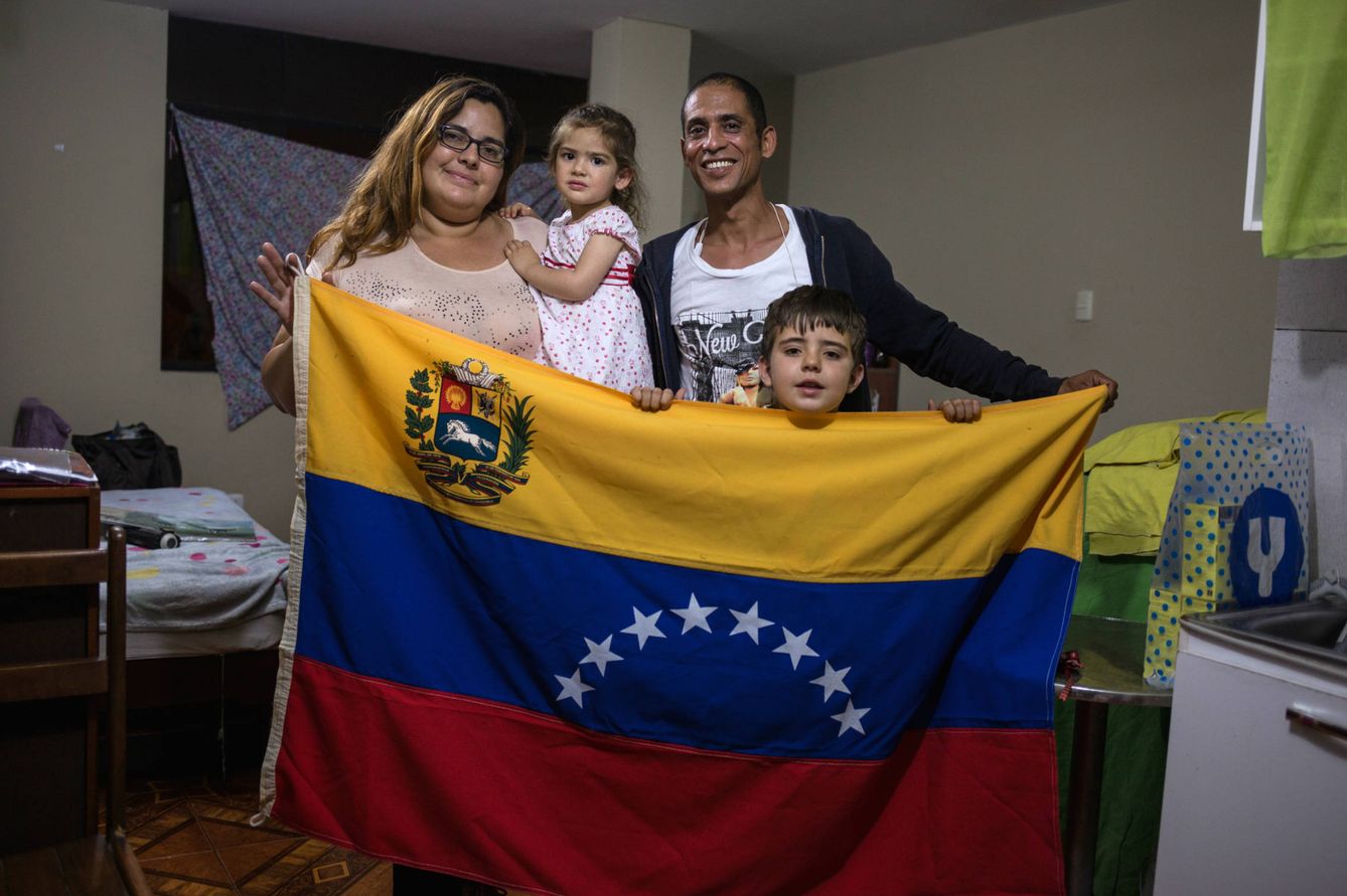 La familia posa con una bandera venezolana en su apartamento. (L. Arango)