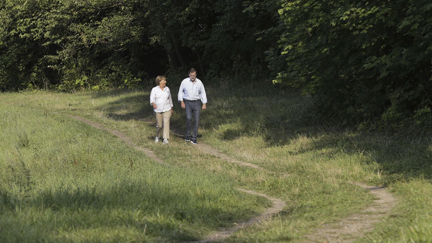 Merkel y Rajoy durante su paseo. (EFE)