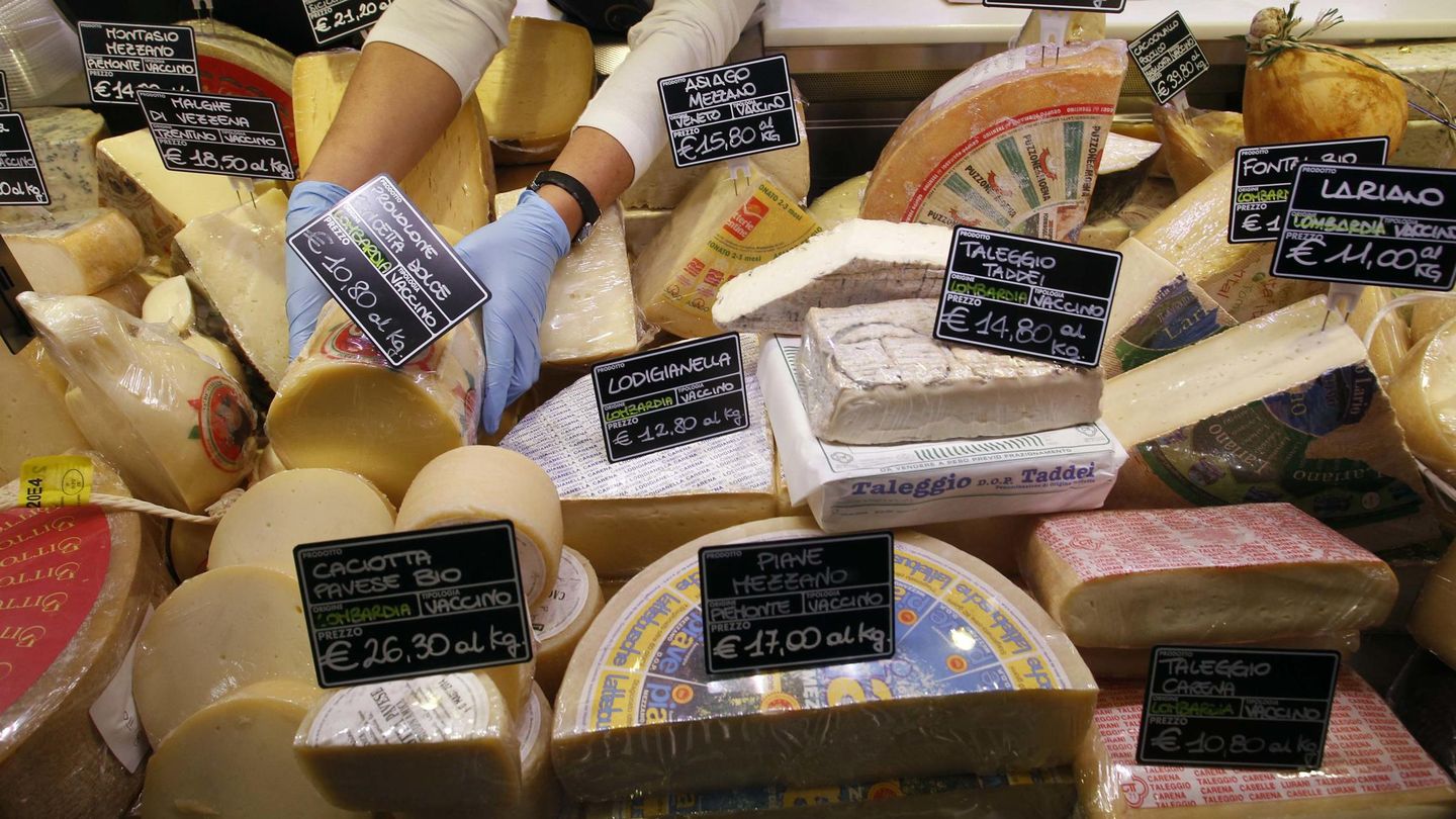Un trabajador ordena precios de quesos en un mercado del centro de Milán (Reuters). 