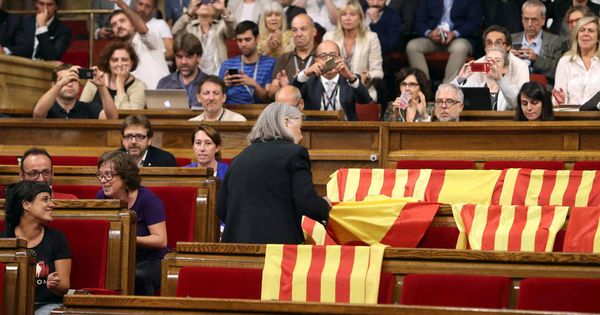 Foto: La exdiputada de CSQP, Àngels Martínez, quitando las banderas de España en el Parlament el 6 de septiembre. (EFE) 