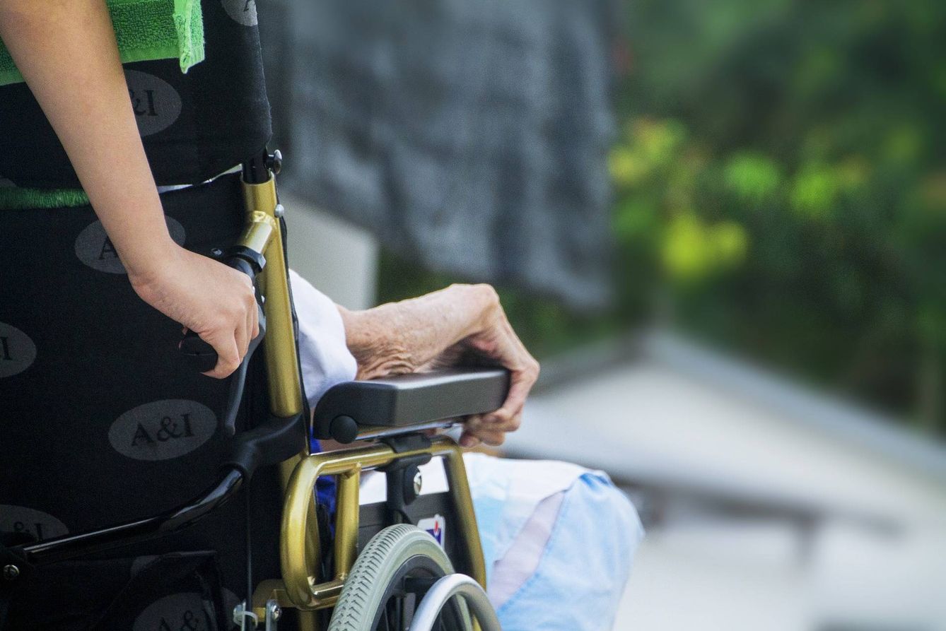 Una cuidadora empuja la silla de ruedas de una anciana. (Pixabay)