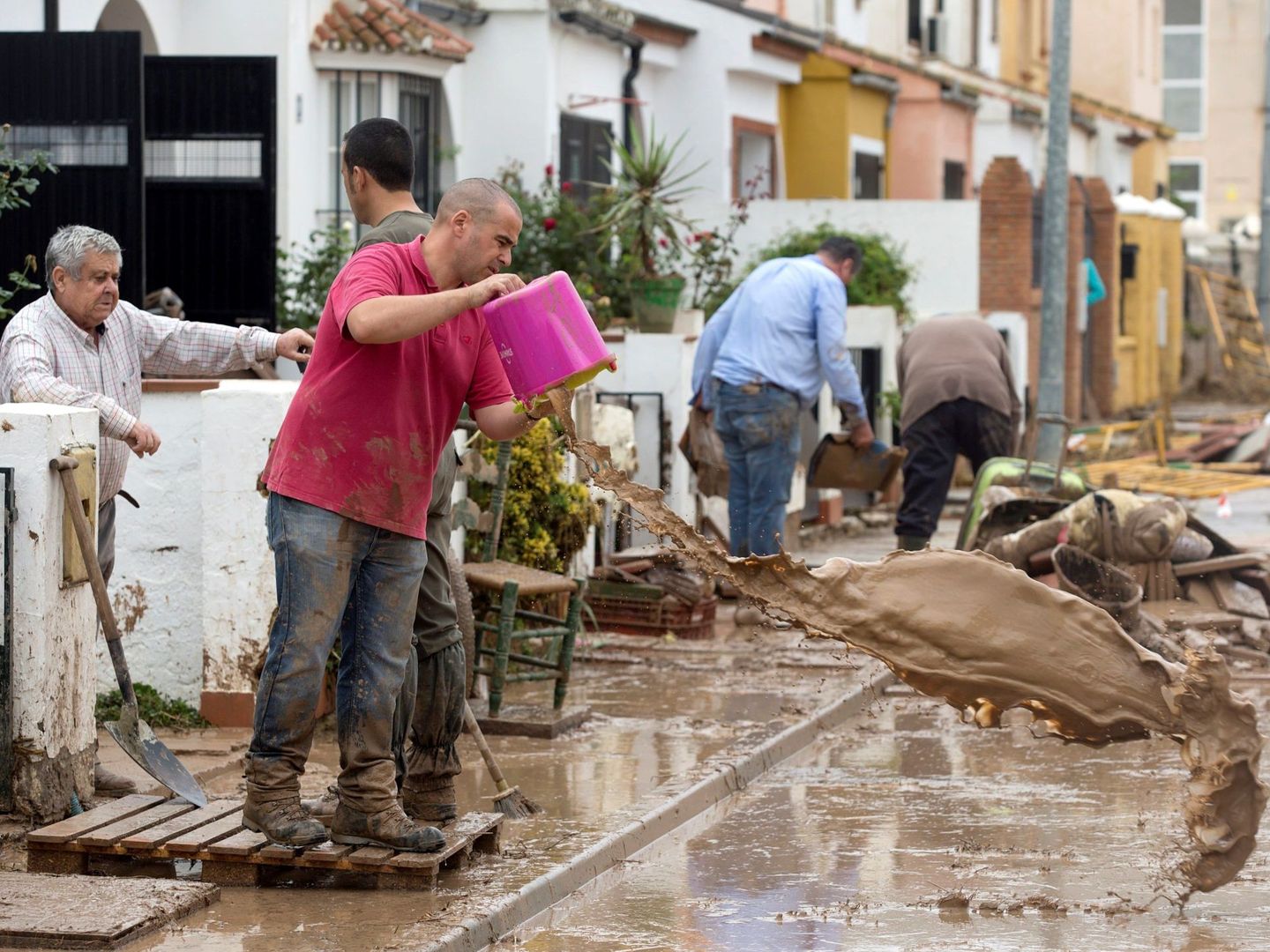 Vecinos de la localidad malagueña de Campillos limpian los desperfectos en viviendas y coches. (EFE)
