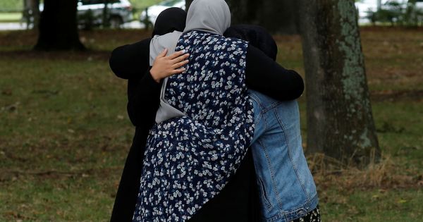Foto: Varias personas se abrazan cerca de la mezquita Masjid Al Noor, en Christchurch. (Reuters)
