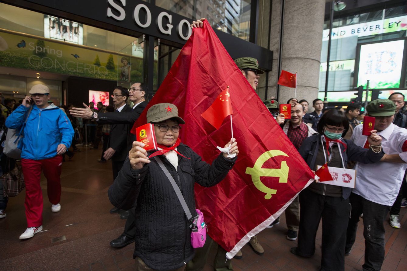 Un manifestante enarbola una copia del Libro Rojo de Mao durante una protesta frente a un centro comercial en Hong Kong, en marzo de 2014. (Reuters)